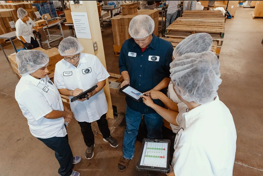 A food safety inspector checking compliance at a beverage production facility, the frontline of a system that depends on more than paperwork to function 